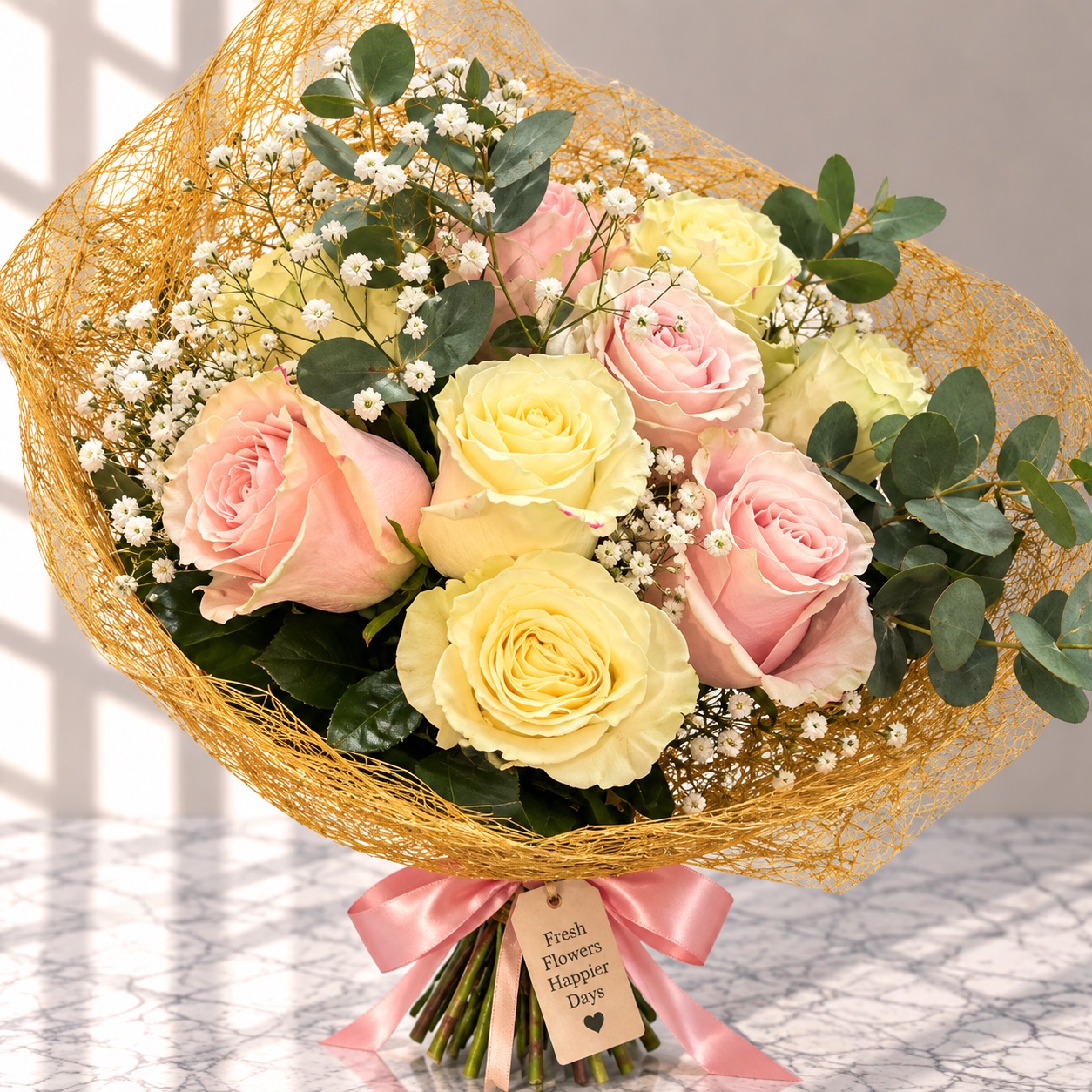 Pink and cream roses with eucalyptus and gypsophila in gold mesh